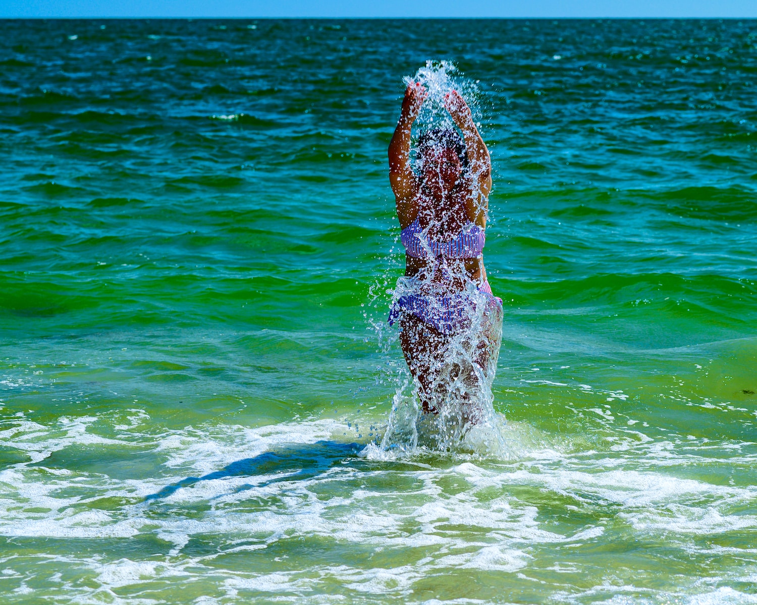 a person standing in the ocean splashing water