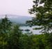 a body of water surrounded by trees and mountains