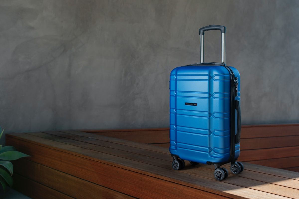 a blue suitcase sitting on top of a wooden floor