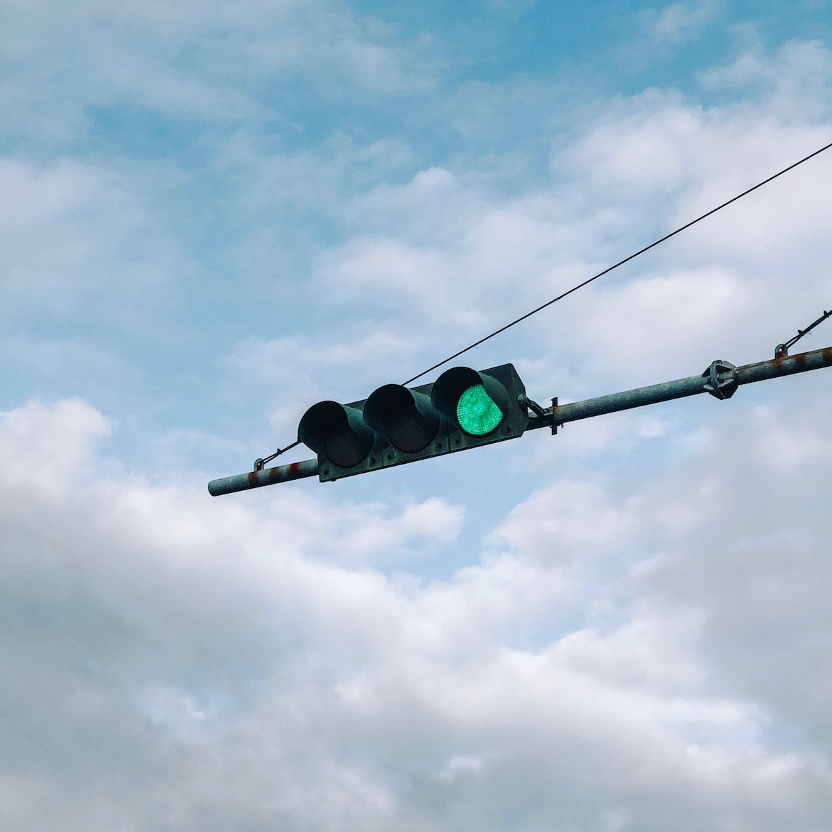 black traffic light under gray cloudy sky