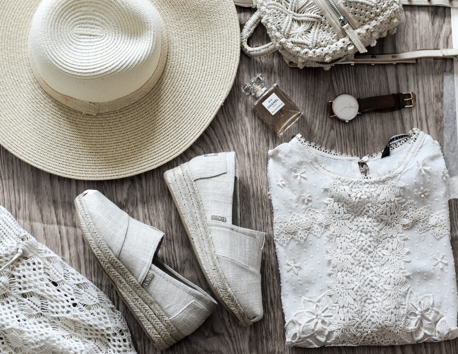 women's white shirt beside brown hat and pair of white sneakers