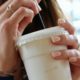 person holding white plastic cup